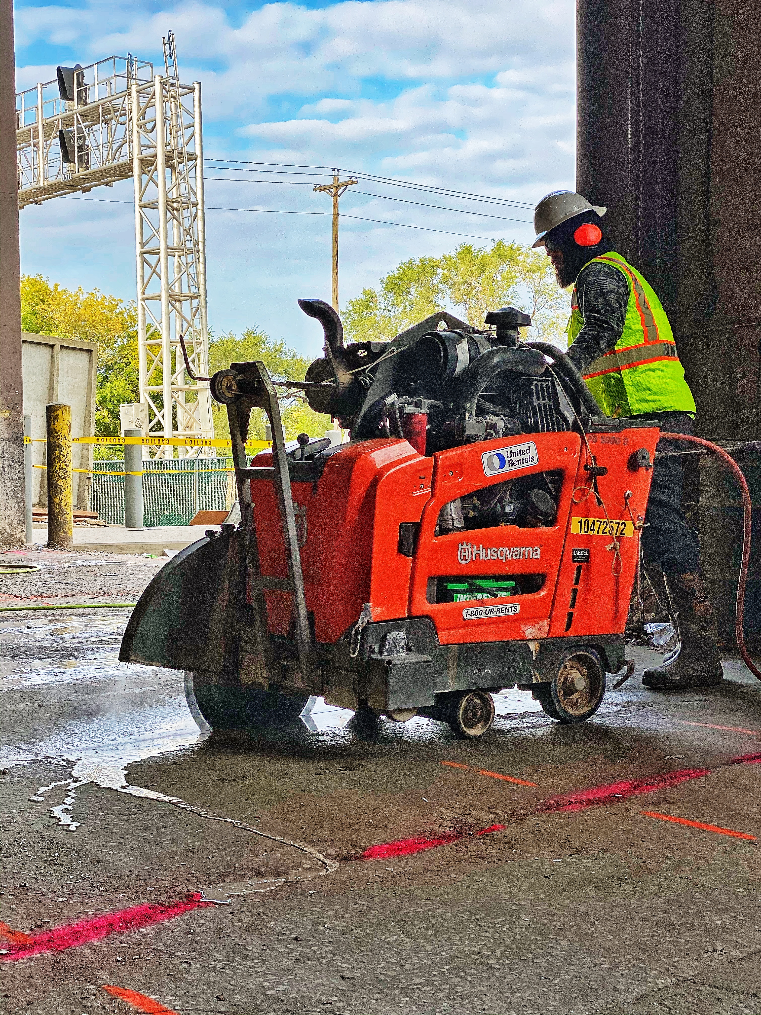 Ride-on slab saw cutting a control joint through a concrete slab