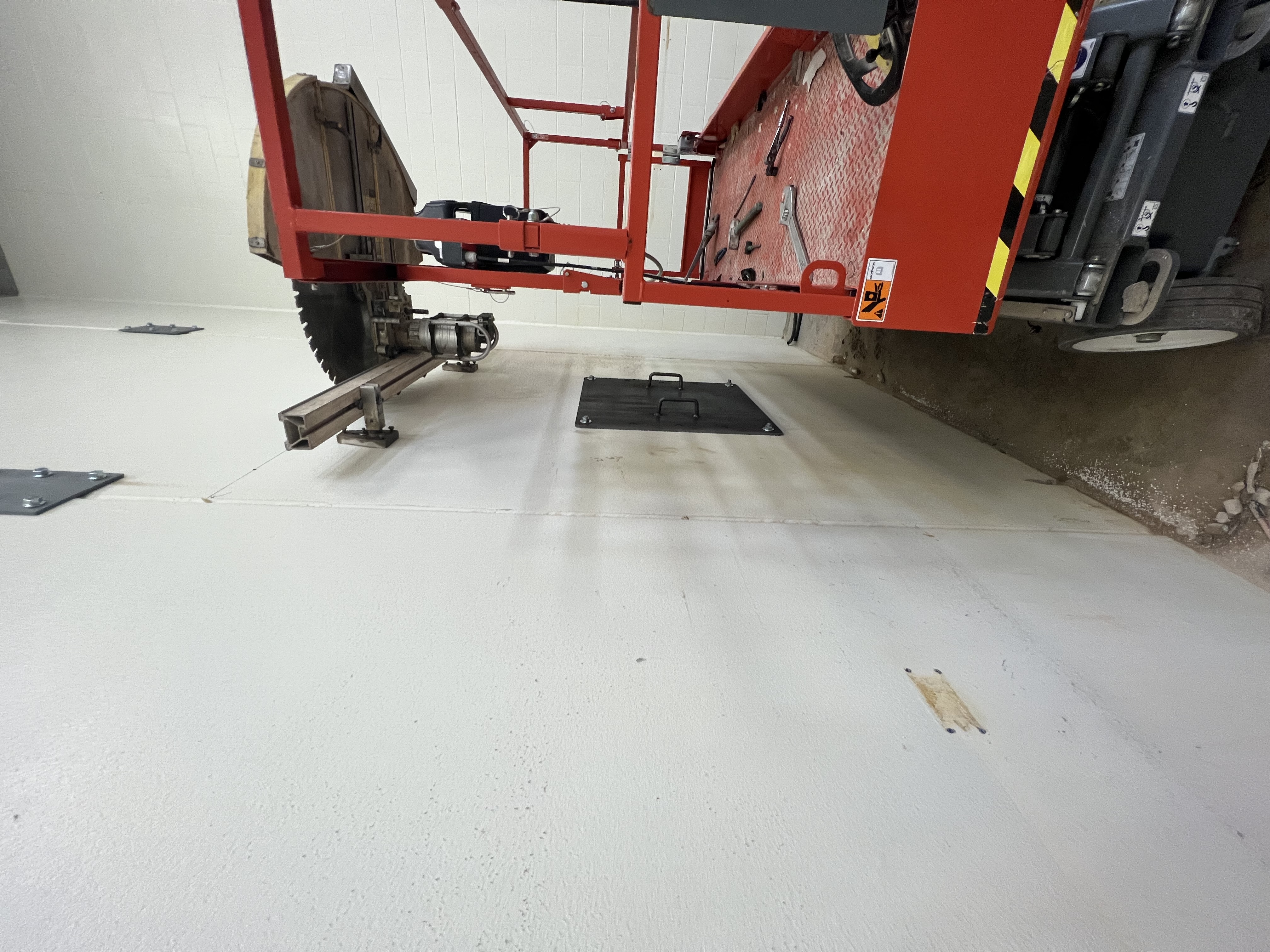 Track-mounted wall saw cutting a vertical opening in a concrete wall